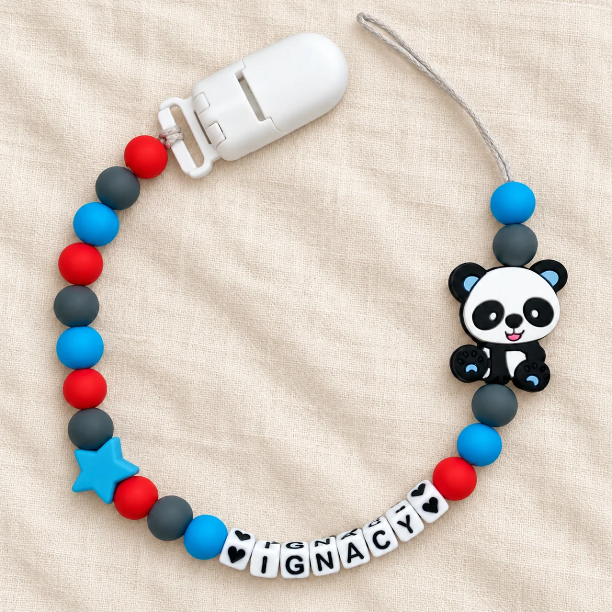 Panda — błękit i czerwień — zawieszka do smoczka z przykładowym imieniem IGNACY
